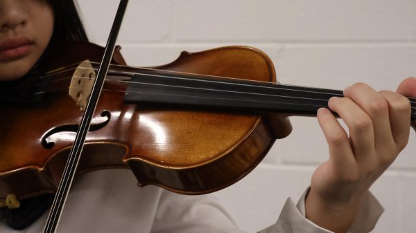 CHS9 student Chloe Chang practices the violin in the Coppell High School Band Hall on Nov. 18. Chang qualified for the UIL Orchestra All-Region competition and has an ardent passion for the violin. Photo by Anvita Bondada
