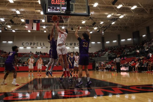 Coppell junior guard Colin Griffith scores a layup while being guarded by Keller Timber Creek junior point guard Robert Moore at CHS Arena on Thursday. The Cowboys to the Falcons, 71-62.