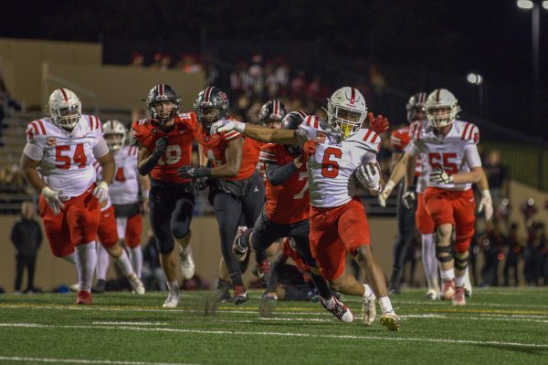 Coppell senior running back O’marion Mbakwe evades Lake Highlands sophomore defensive back Holden Layne on Friday at John Clark Stadium. The Cowboys defeated the Wildcats, 38-10, in the Class 6A Division I Region I area playoffs. Photo by Kayla Nguyen 