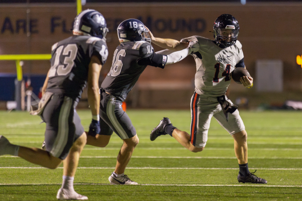 Coppell senior quarterback Edward Griffin stiff arms Flower Mound junior safety Corbin Ridenour on Friday at Neal E. Wilson Jaguar Stadium. The Cowboys defeated the Jaguars, 42-14. Photo by Kayla Nguyen