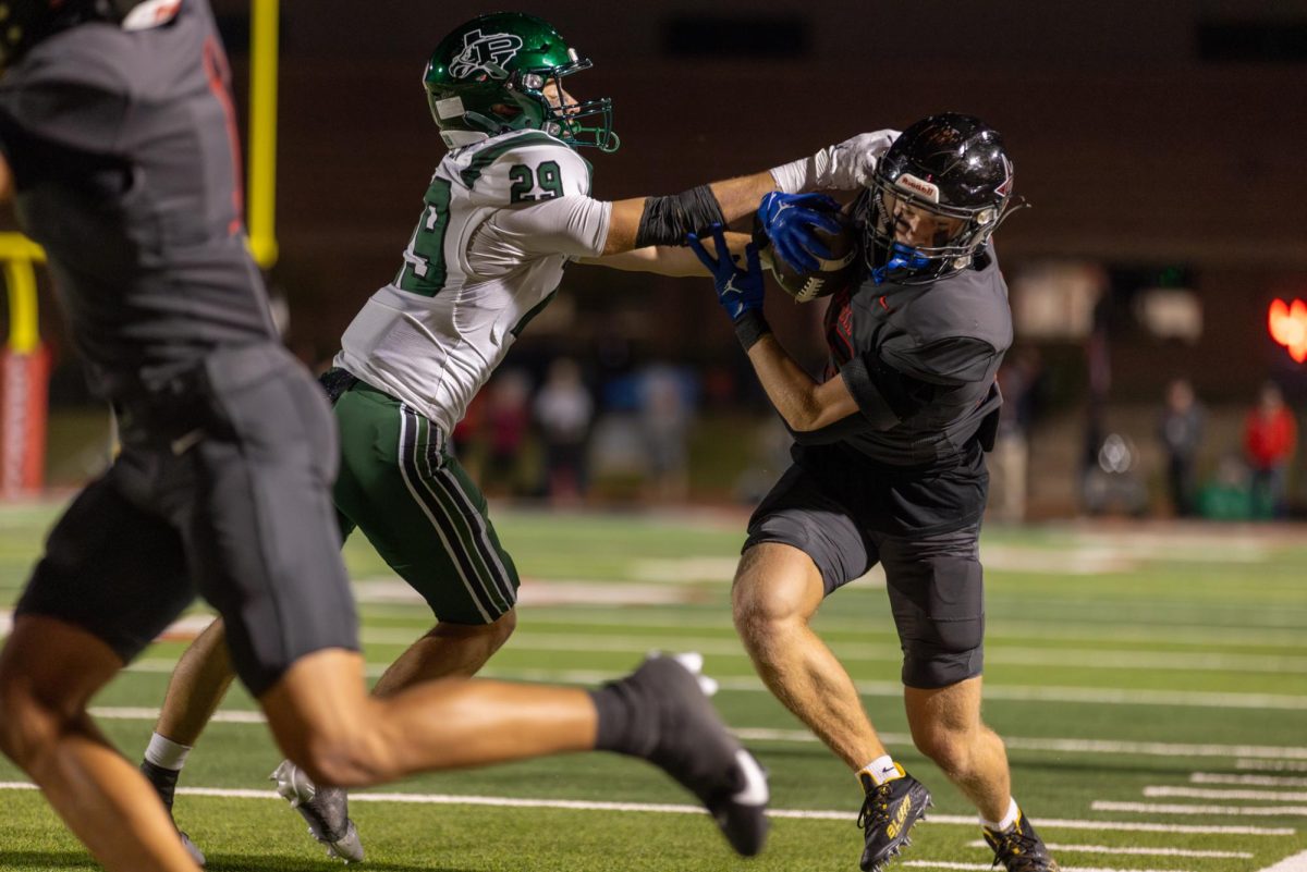 Coppell senior wide receiver Harry Hassmann holds off Prosper sophomore linebacker Fahd Allan at Buddy Echols Field on Nov. 15. The Cowboys defeated Prosper in the Class 6A Division I Region I bi-district playoffs, 35-27. Photo by Kayla Nguyen.