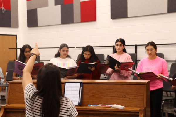 Coppell High School A Capella Choir seniors Saanvi Mantena, Aahana Behera, Monica Tupurani, Iris Kim and junior Anju Anand rehearse for the upcoming Texas Music Educators Association Convention in the choir room. The TMEA Convention annually brings musicians from Texas to partake in workshops, rehearsals and performances. Photo by Kushal Rambhapuri