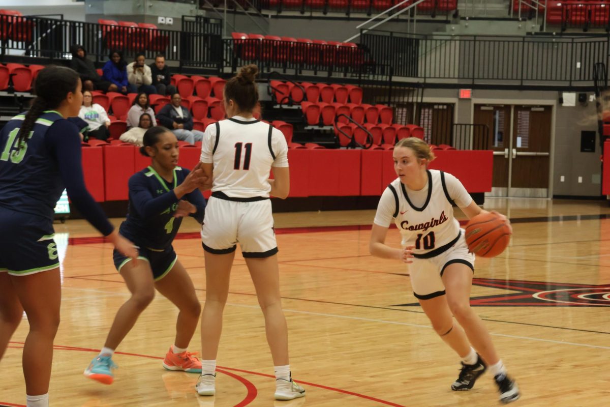 Coppell senior shooting guard Landry Sherrer drives past senior forward Paige Slater’s screens Eaton opponent junior shooting guard Mika Welsh. The Cowgirls defeated the Eagles, 56-46, Tuesday night at Coppell High School Arena.