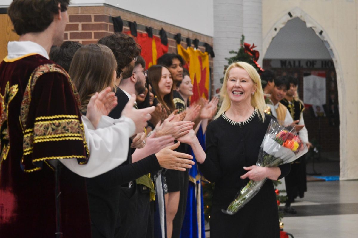 Coppell Madrigal singers’ founder Jolene Webster receives high-fives from Madrigals and alumni in the CHS Commons on Friday. The Coppell Madrigal singers choir hosted its 30th annual feast on Friday and Saturday.