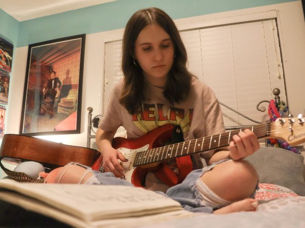 Coppell High School junior Alyssa Gray strums the melody to “Snowman” by Sia on her electric guitar in her room on Dec. 11. Gray loves music from the 1950s and 1960s, introduced by her father, Adam Gray. (Photo by Caitlyn Conception)
