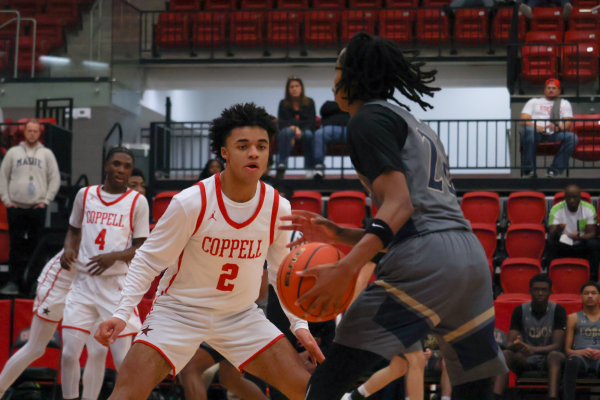 Coppell junior guard Isaiah Fleming defends Little Elm junior guard Kensington Candler at CHS Arena on Tuesday. The Cowboys defeated the Lobos, 67-60, acquiring their first District 5-6A win of the 2024-25 season. 