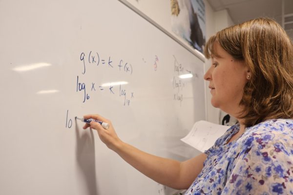 Coppell High School math teacher Karie Kosh solves an equation on her whiteboard during fifth period on Nov. 19. Kosh is well known for her enthusiasm for teaching and has been selected as The Sidekick Volume 36 No. 3 Teacher of the Issue.