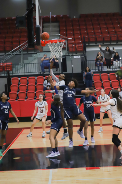 Coppell senior forward Kennedy Paul makes a buzzer beater shot against Little Elm junior Staci Pettie on Tuesday at the CHS Arena. The Cowgirls defeated the Lady Lobos, 42-41. Photo by Sohana Singh