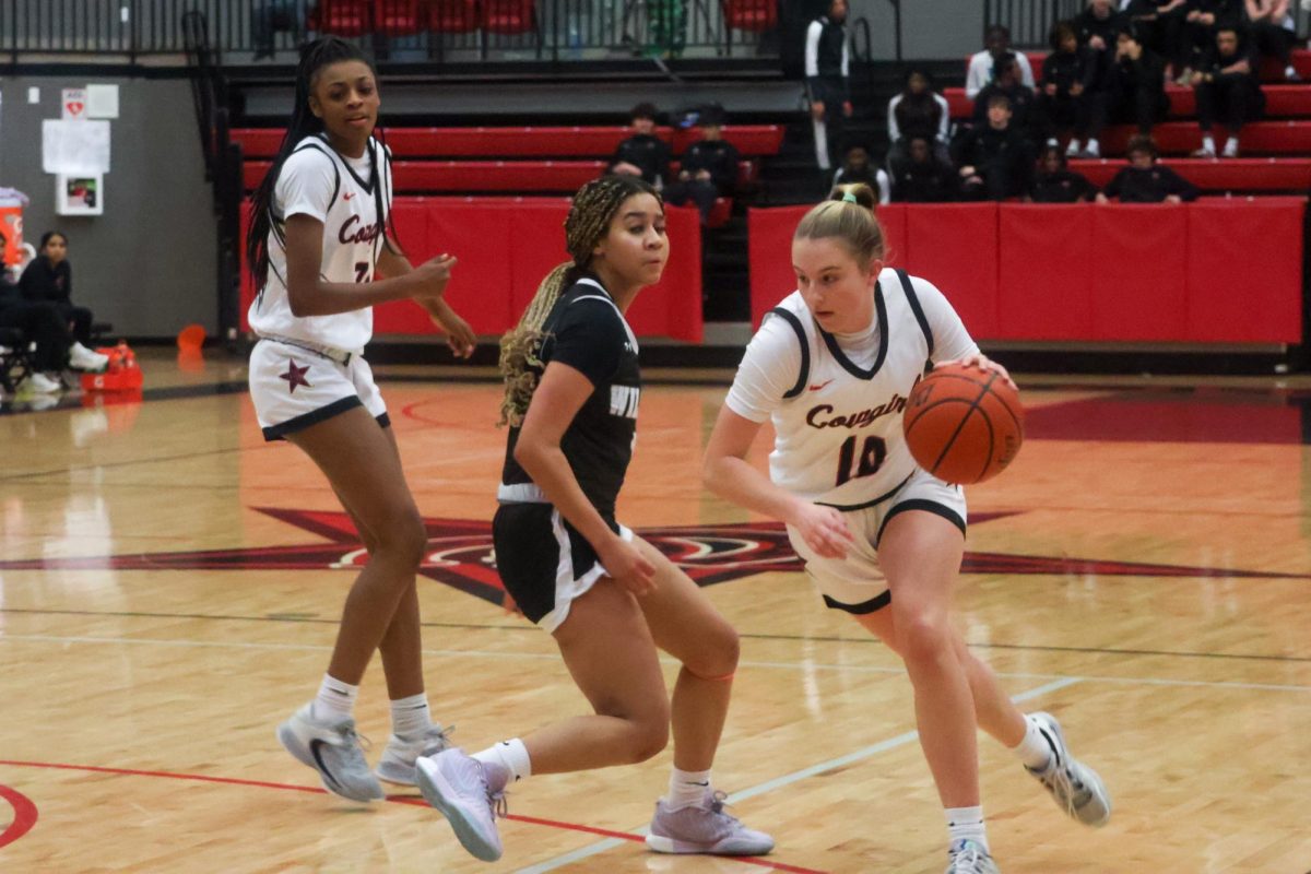 Coppell senior guard Landry Sherrer drives to the basket, beating Denton Guyer senior guard Amaya Langford off the dribble, for a layup at CHS Arena on Friday. The Wildcats defeated the Cowgirls, 63-38. 