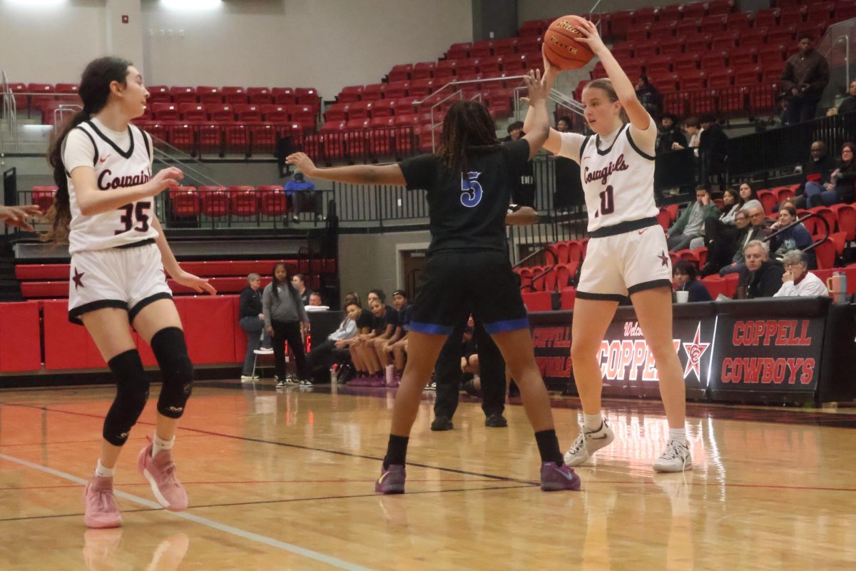 Coppell senior guard prepares to pass to freshman guard at CHS Arena on Tuesday. The Cowgirls defeated the Hawks, 43-26.