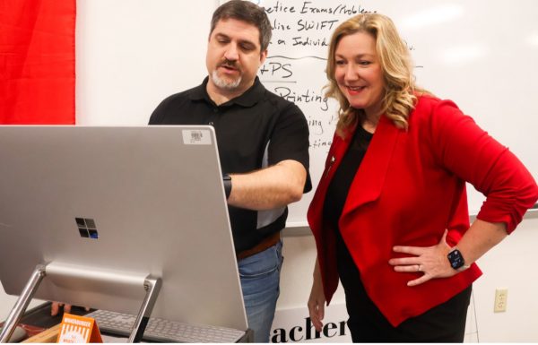 Coppell High School learning coach Monica Champagne assists engineering teacher Grant Garner with a technology issue. Champagne works with teachers and students to enhance their teaching and learning experience. Photo by Dayami Granados.
