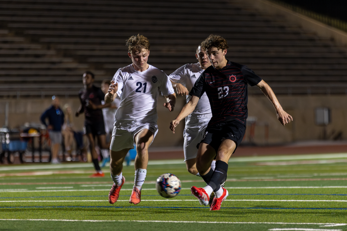 Coppell junior forward Liam Spiller breaks past Flower Mound senior defender Andrew Ritzert and junior defender Oliver Marrujo to score the first goal of the match for the Cowboys during the first half. The Cowboys defeated the Jaguars, 2-1, at Buddy Echols Field on Friday. Photo by Kayla Nguyen