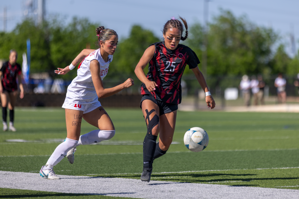 Coppell senior midfielder Summer Chen drives past Lake Travis junior forward Amelia Clark at Birkelbach Field in Georgetown on April 12. The Cowgirls defeated Lake Travis, 6-2, to win the Class 6A Division I state championship for the first time in 10 years. Photo by Kayla Nguyen. 