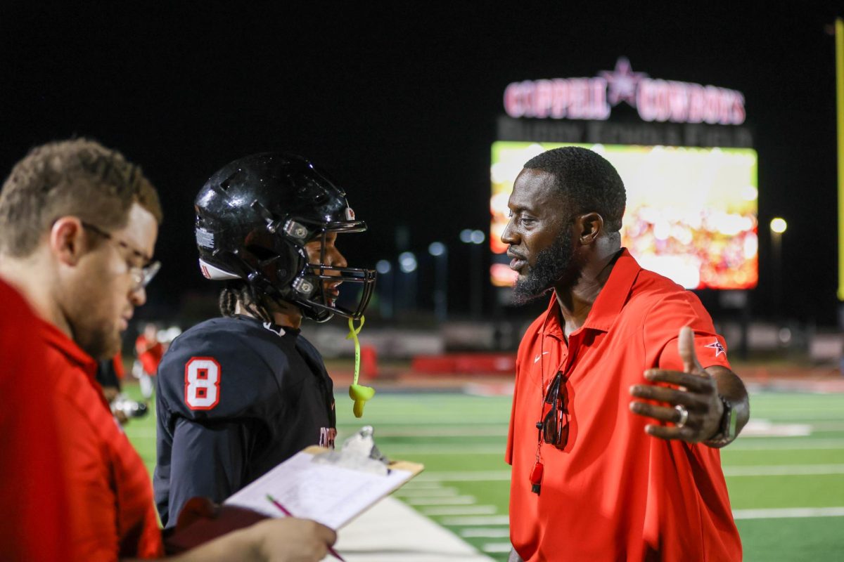Coppell coach Antonio Wiley communicates with junior cornerback Isaiah Witherspoon during the scrimmage against Lake Highlands at Buddy Echols Field on Thursday. The Cowboys open the 2025 season on Friday at Sachse. Photo by Naila Ali