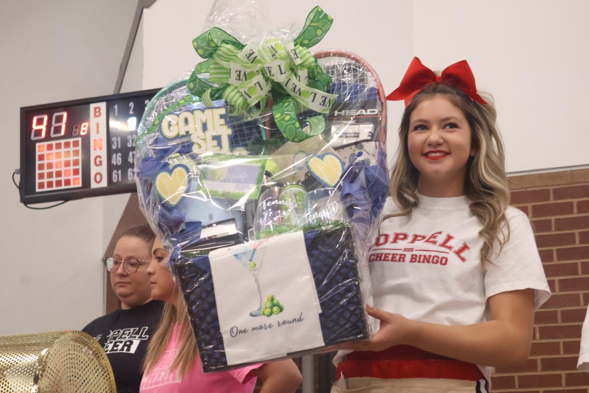 Coppell High School senior cheerleader Yansy Martinez presents a winner’s gift package on Friday in the Coppell High School Commons. The annual Cheer Bingo fundraiser is a fun, friendly competition supporting the CHS cheer team.