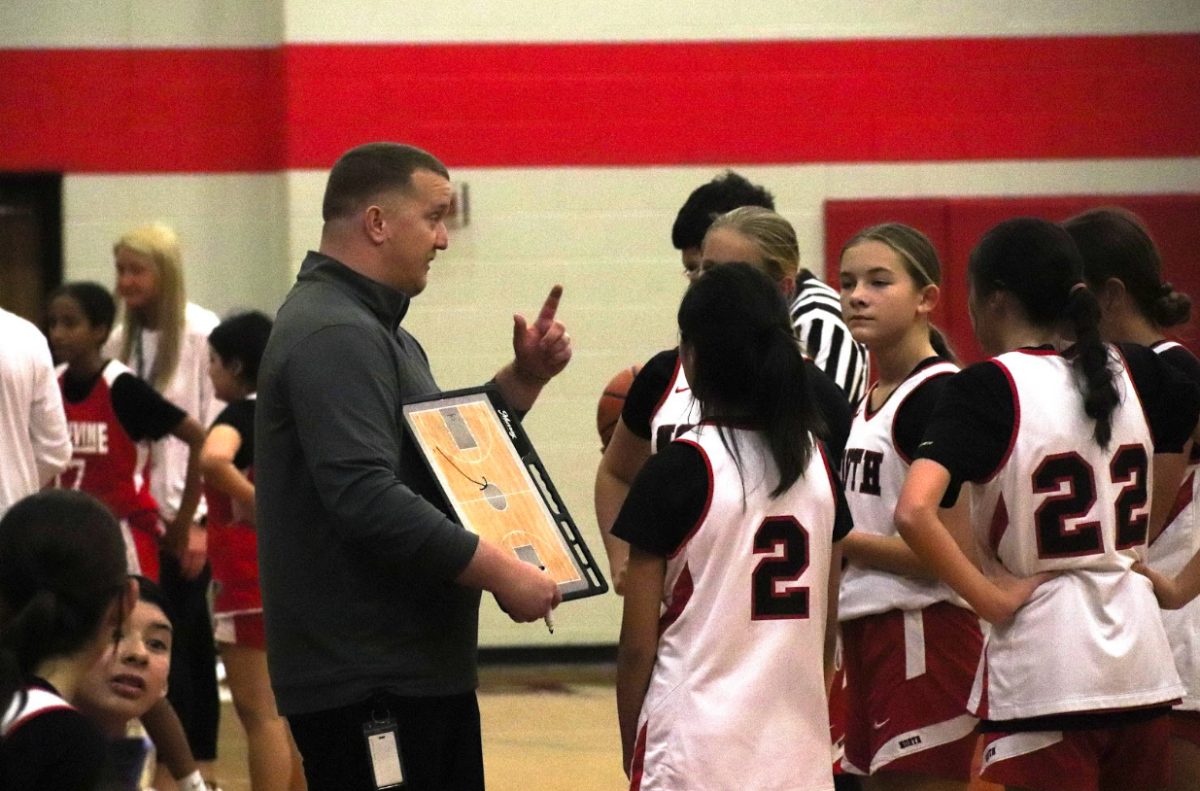 Coppell Middle School North coach Garrett Barley huddles with his team during a game in the CMSN large gym on Dec. 11. Barley is known for making a significant impact at CMSN, fostering both athletic programs and personal growth among students. Photo by Chloe Smith