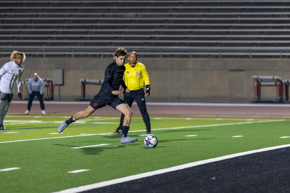 Coppell senior defender Brooks Kaiser scores on a free kick against Denton Guyer freshmen goalkeeper Braylon Moss on Thursday at Buddy Echols Field. The Cowboys defeated the Wildcats, 3-2, in the second District 5-6A match. Photo by Naila Ali