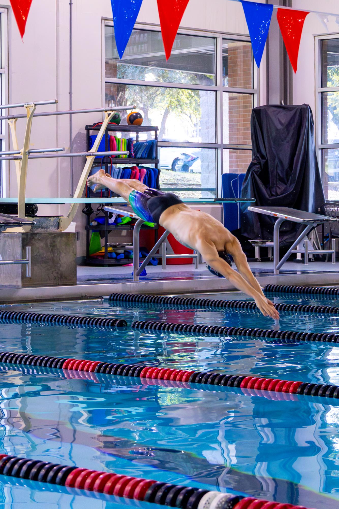 Coppell High School senior Gabriel Campos dives off the diving block at Coppell YMCA during practice. Campos signed with Penn State University in November, treading closer to his dream of competing in the Olympics. Photo by Eirene Park