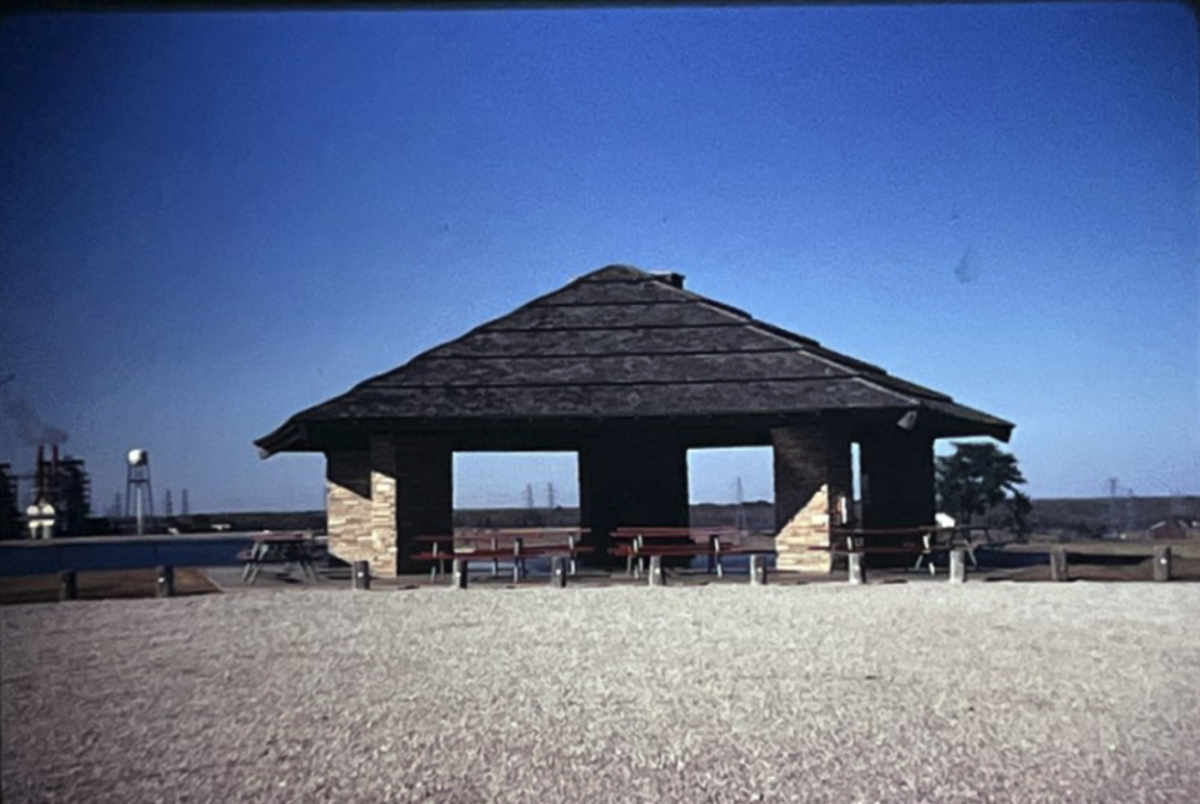 Behind a pavilion for employees near North Lake, the now-demolished North Lake Steam Electric Station can be seen (left). North Lake and the bordering Cypress Waters development carry a complex history involving construction and controversy. Photo courtesy University of Texas at Austin Alexander Architectural Archives