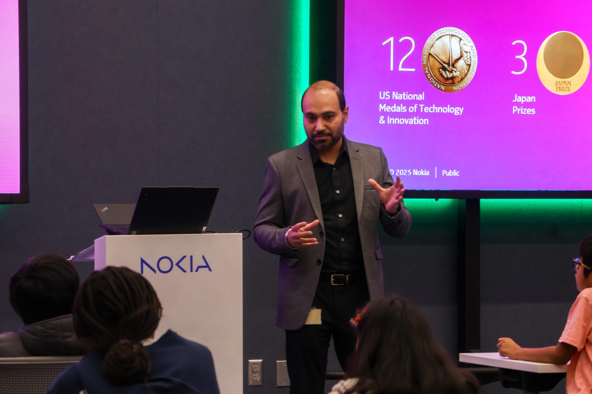 Nokia senior standardization expert Gagadeep Bhatti introduces SAGE participants to the Nokia brand and its initiatives on Dec. 16 at Nokia in Cypress Waters. SAGE collaborated with Nokia for an artificial intelligence seminar and activity tour.