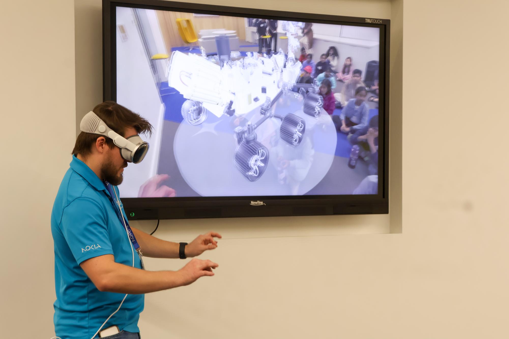 Nokia staff member Blake Martin provides a visual demonstration of how visual reality works on Dec. 16 at Nokia in Cypress Waters. SAGE collaborated with Nokia for an artificial intelligence seminar and activity tour.
