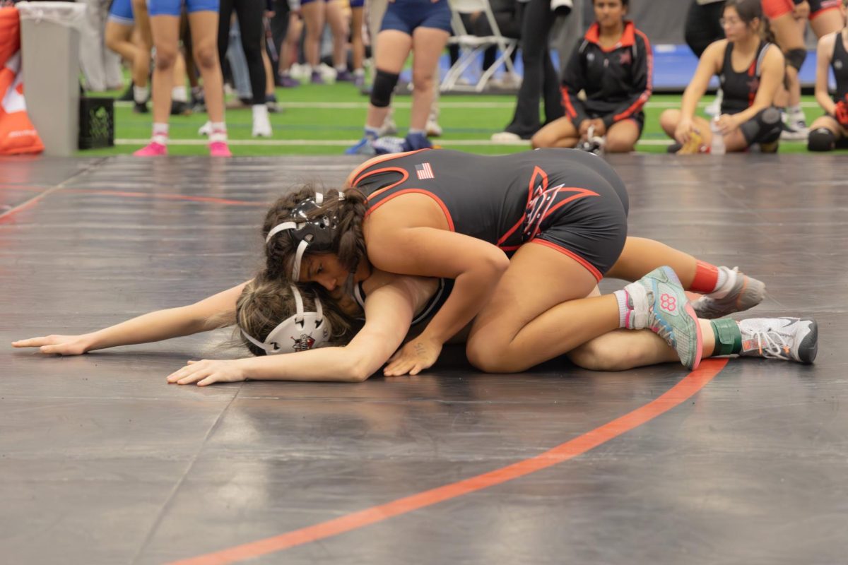Coppell sophomore Averie Gonzales wrestles against Centennial on Nov. 20 at CHS Indoor Facility. The Cowgirls controlled the meet with a final score of 248 points. 