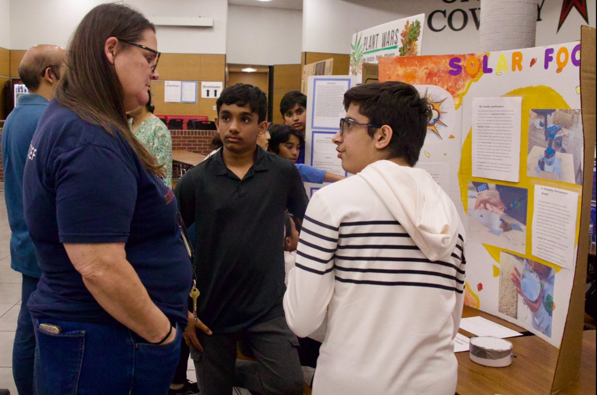 Coppell Middle School North eighth graders Pavansanjay Sankiiraj and Kavish Dhawan explain their solar focus project to Science Fair coordinator Holly Anderson on Tuesday at the Coppell High School Commons. Coppell ISD middle and high school students come together to showcase their projects, to learn from others and get feedback from other students.