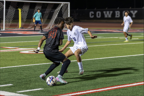 Coppell junior forward Ian Wanemba dribbles against Flower Mound sophomore midfielder Gustavo Pacheco. The Cowboys won against the Jaguars, 6-1, Friday at Buddy Echols Field. Photo by Prisha Hooda
