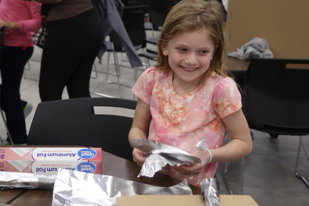 Second grader Gianna Colker uses aluminum foil to create a building on Thursday in the structural engineering booth in the commons. The Coppell High School Society of Women Engineers hosted the Introduce a Girl to Engineering Day event to introduce girls grades kindergarten through 12th grade to the various disciplines of engineering. 
