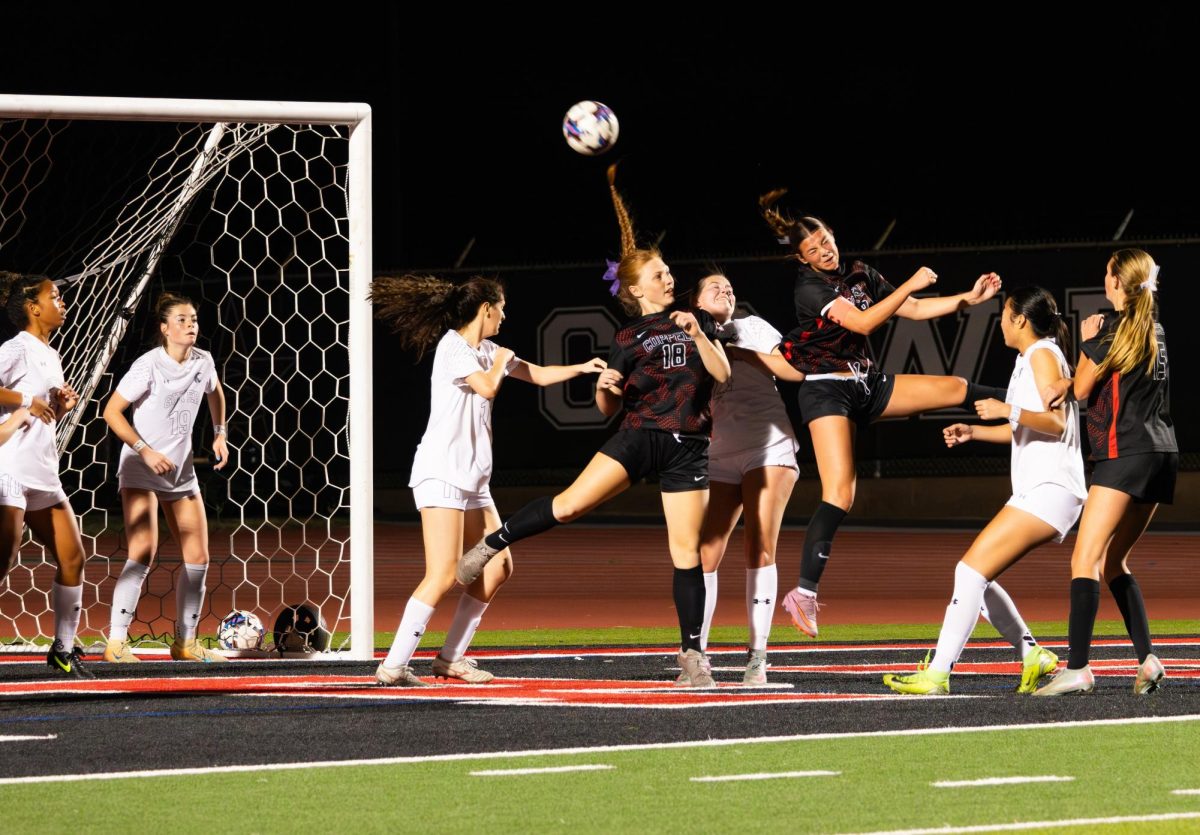 Coppell junior forward Emeline Holder (middle) makes a header alongside junior defender Zoe Harrison (left) and freshman defender Lainey Wells (right) as Denton Guyer defends on Friday at Buddy Echols Field. The Cowgirls defeated the Wildcats, 3-1. 
