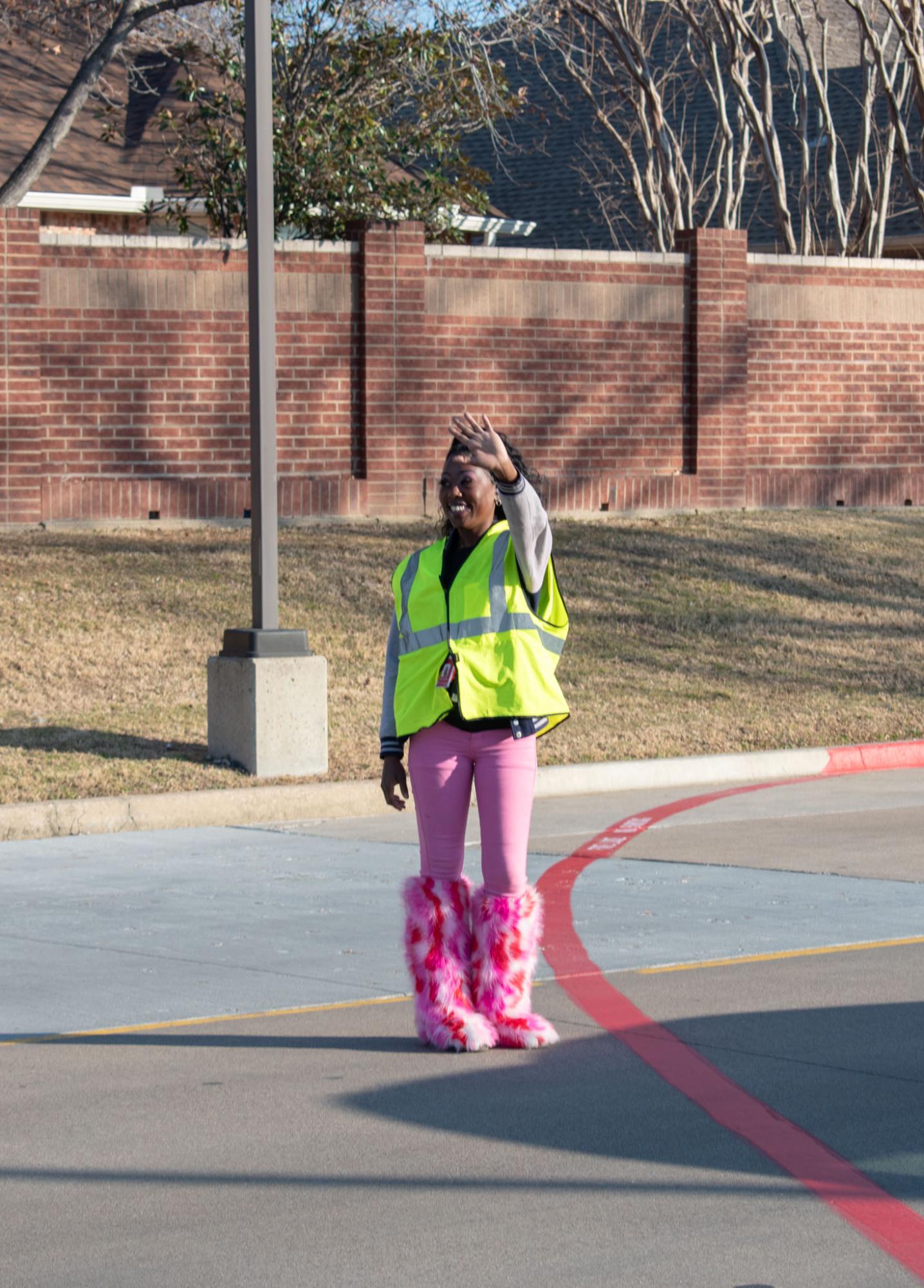 Coppell High School security Neisha Hartfield guides the traffic exiting the parking lot after school. Heartfield is a hard-working security guard with a glowing personality and a strong sense of responsibility.