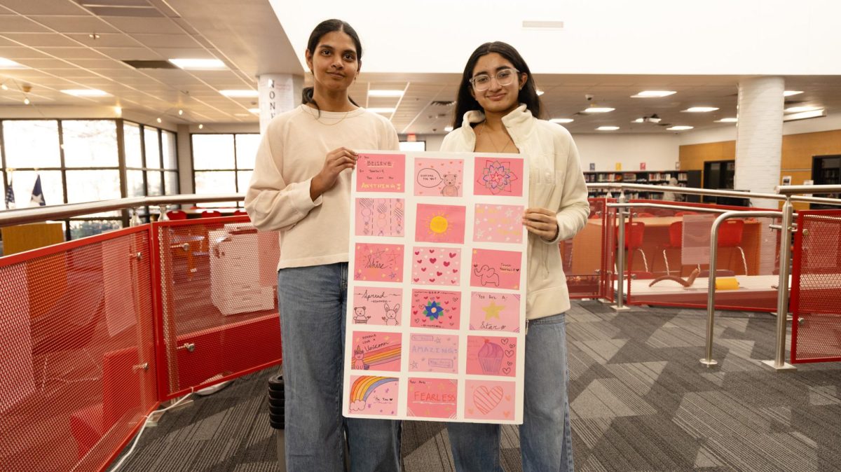 Coppell High School seniors Aasritha Yanamala and Siri Vemireddy display murals with notecards written by volunteers. SmilesThruArt is a student-led organization that brings art therapy and creative activities to children in hospitals.