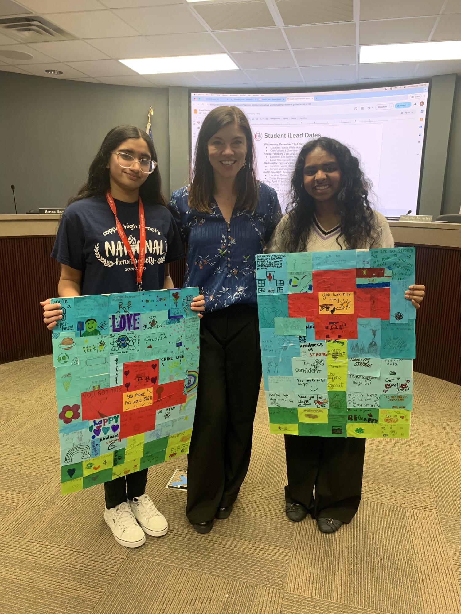 Coppell High School seniors Siri Vemireddy and Saanvi Chiliveru display their murals with Coppell ISD trustee Leigh Walker on Feb. 26, 2025 at Vonita White Administration Building. SmilesThruArt is a student-led organization that brings art therapy and creative activities to children in hospitals. Photo courtesy Siri Vemireddy