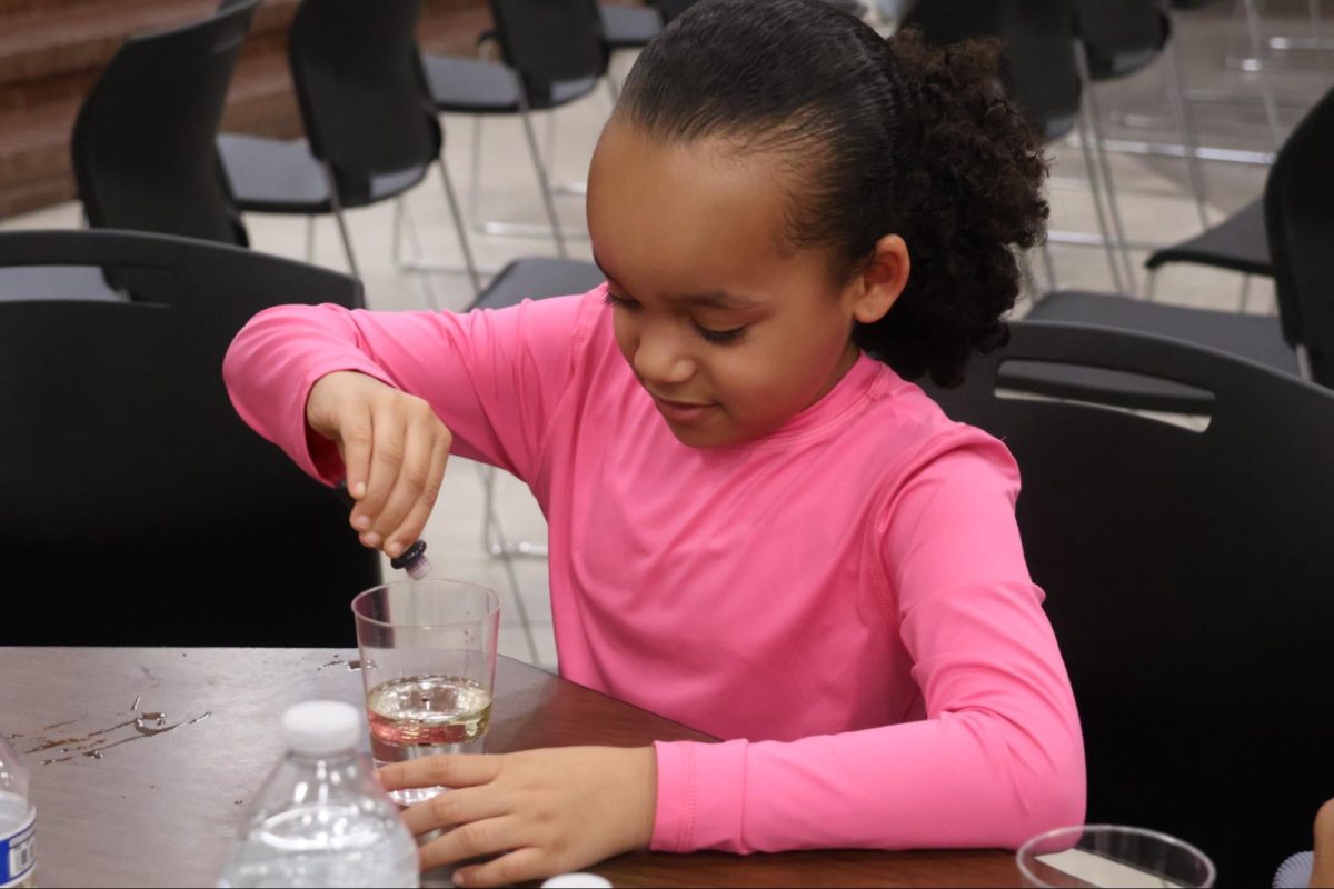 Attendee Yana Farquharson learns how different liquids interact when mixed together in the chemical engineering booth on Feb. 26 in the CHS Large Commons. The CHS Society of Women Engineers hosted Introduce a Girl to Engineering Day to introduce girls in kindergarten through 12th grade to the various different disciplines of engineering.