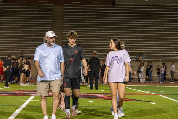 Mathew Spiller, Coppell senior forward Liam Spiller and 2024 graduate Ella Spiller walk out during Senior Night prior to the match against Denton Braswell on March 3 at Buddy Echols Field. The Cowboys defeated the Bengals, 2-1.