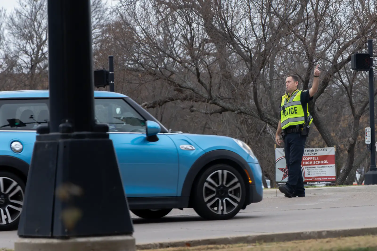 A Coppell Police Department officer stops a vehicle on Cowboys Drive on the morning of Feb. 18. Coppell High School was closed on Feb. 18 following a bomb threat.