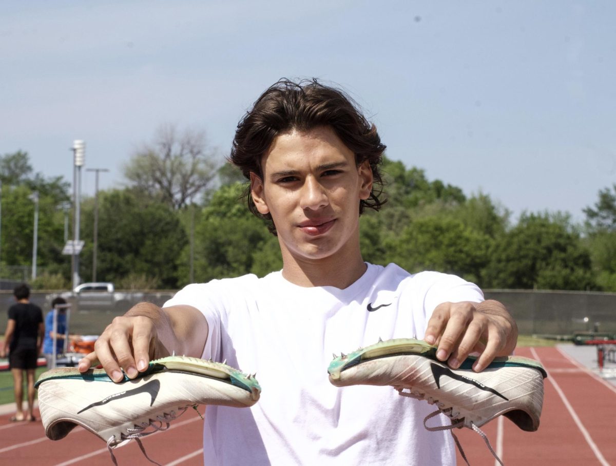 Coppell sophomore hurdler Miguel Lopez holds his spikes at the track at Buddy Echols Field. Lopez began his hurdling journey at Coppell Middle School North after recognizing personal talent.