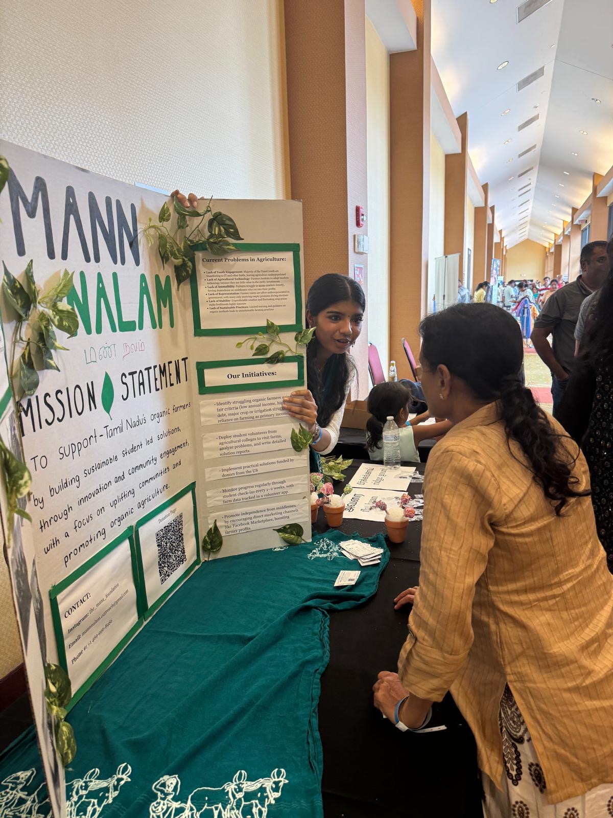 Coppell High School junior Iniya Nandakumar presents Mann Nalam to visitors to fundraise and distribute free seed packets at a nationwide Tamil diaspora event in Dallas. Nandakumar continues her grandfather N.S. Palanisamy’s legacy of advocating for farmers facing unfair treatment in South India. Photo courtesy Iniya Nandakumar.