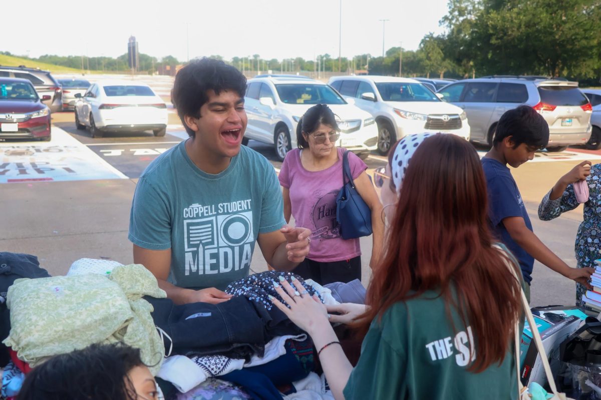 The Sidekick faculty/staff editor Jay Vernekar converses with entertainment editor Marli Field on Saturday at the Coppell High School student parking lot. The Sidekick annual garage sale raises money for the program’s expenses. 