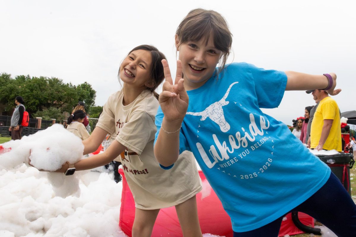 Lakeside Elementary School students Ellin M. and Harper L. play in foam on Friday at Lakeside Elementary School. The Lakeside Stampede is an annual event featuring a one-mile obstacle course for all grades with T-shirts designed by the students.