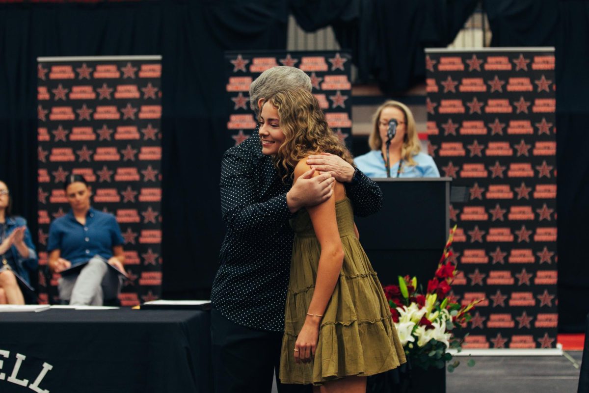 Coppell High School Principal Laura Springer congratulates senior Alexis Patterson for track and field achievements on Tuesday at CHS Arena. The Senior Awards Ceremony recognizes the excellence of seniors throughout their high school career. Photo by Naseeha Masood 
